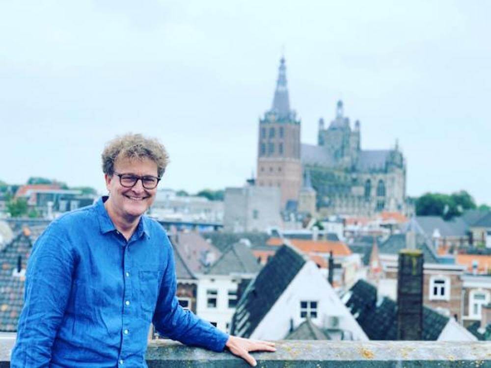 Patrick Timmermans op een dakterras met op de achtergrond de binnenstad van Den Bosch