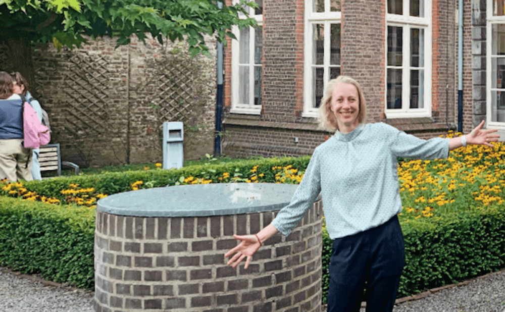 Claartje Rasterhoff staand op de binnenplaats van de faculteit Kunst en Sociale Wetenschappen van de Universiteit Maastricht