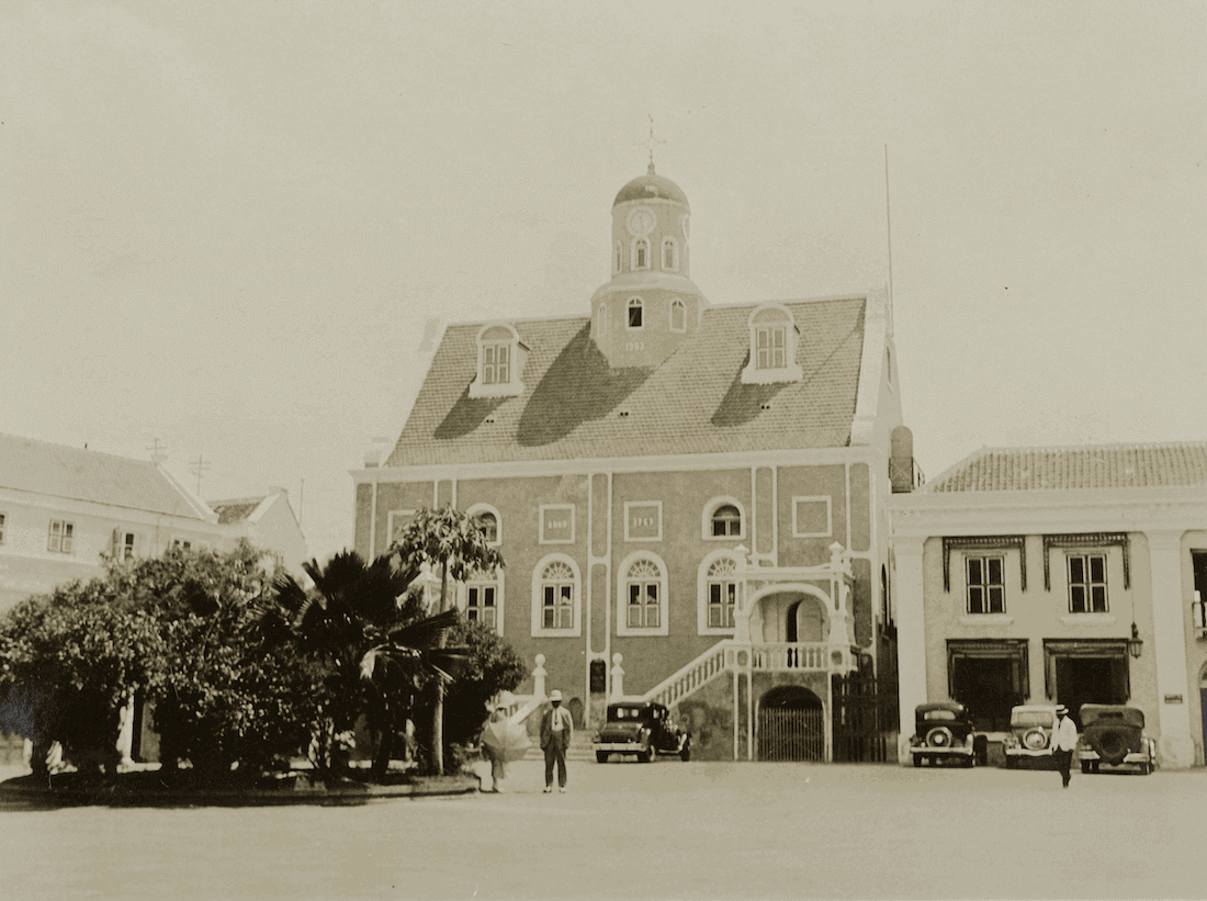 Historische opname van kerk met plein, links staat een rij bomen