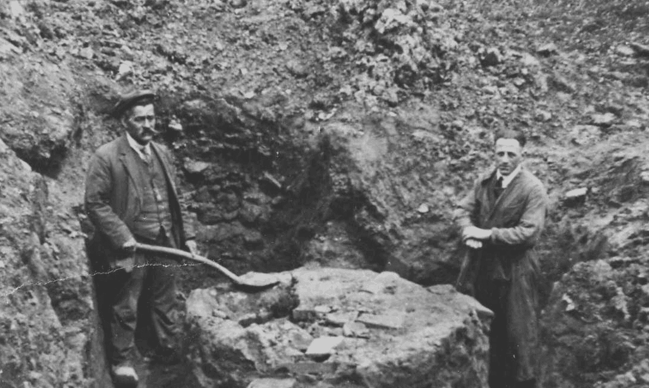 Twee mannen met een schop staan bij een archeologische opgraving in Berg en Dal, 1929