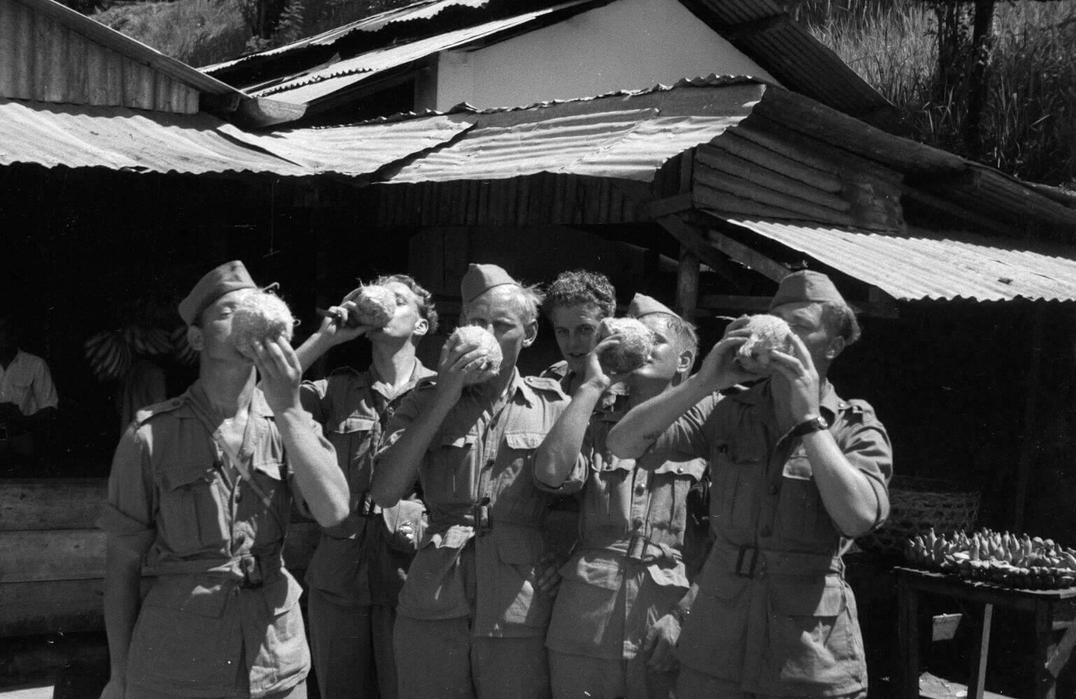 Militairen drinken klappermelk uit kokosnoten in Sabang, Indonesië